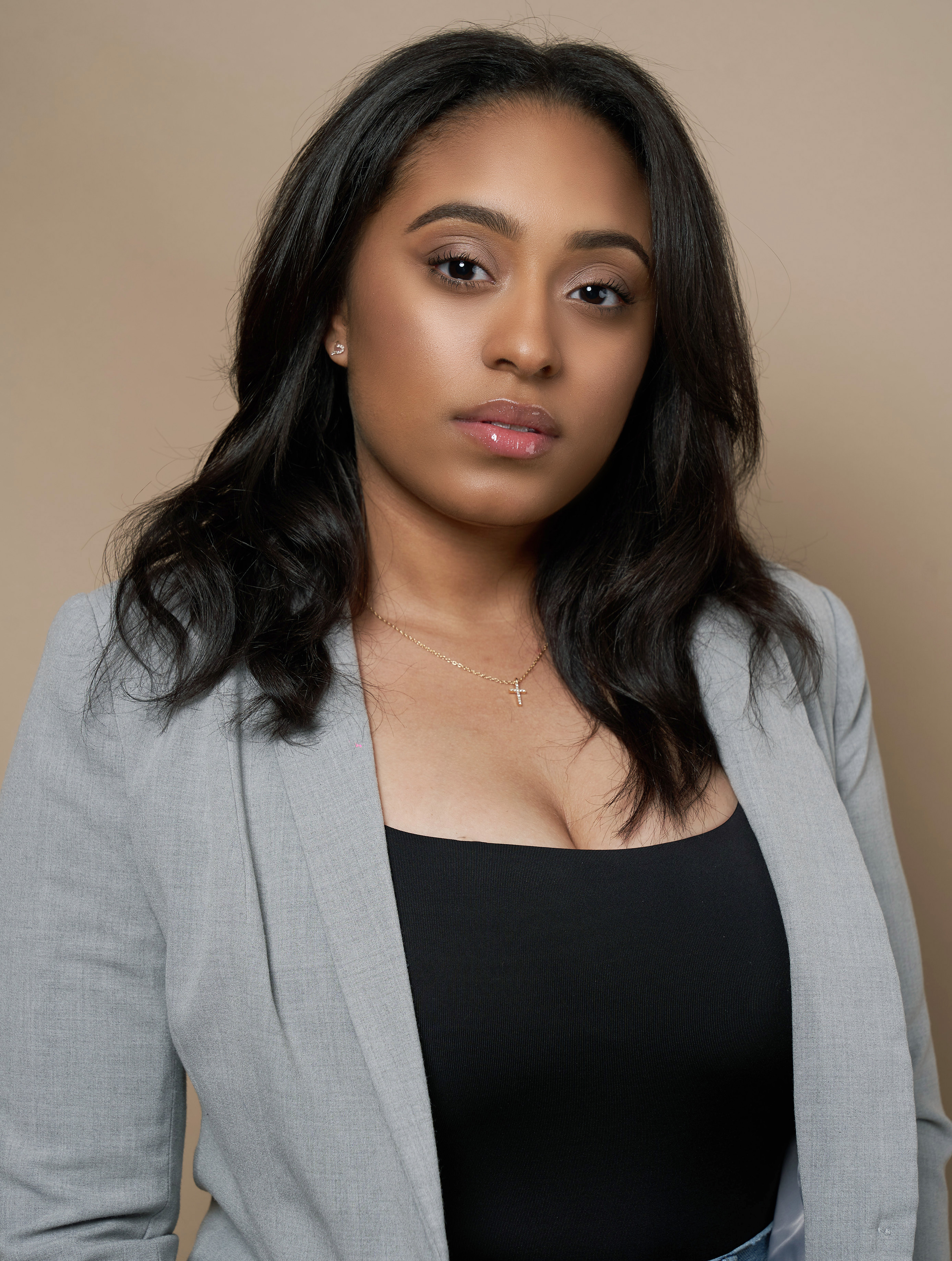 Actor headshot wearing a grey blazer against a neutral backdrop